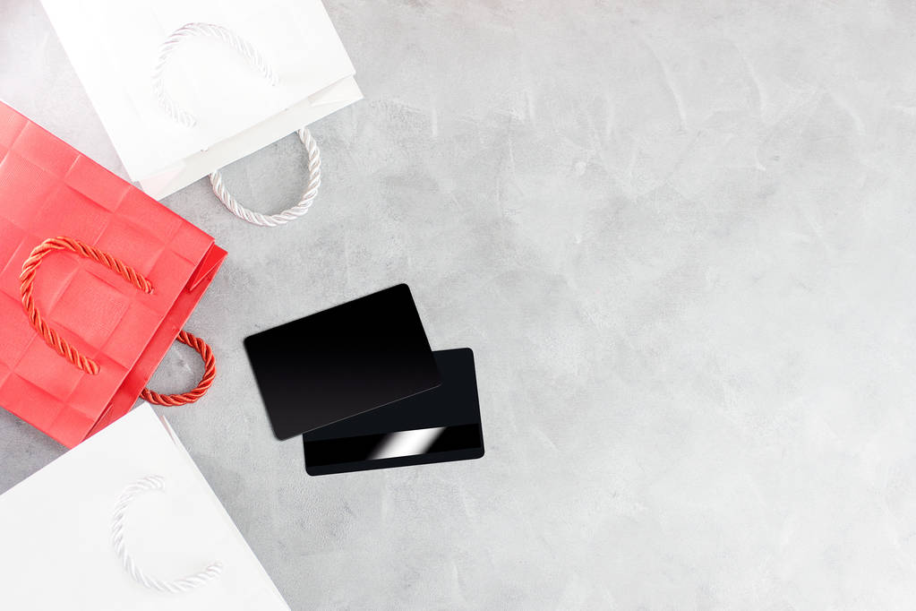 fondo de compras: bolsas de papel rojo y blanco y tarjetas de crédito. Concepto de descuento. Espacio de texto
  - Foto, Imagen