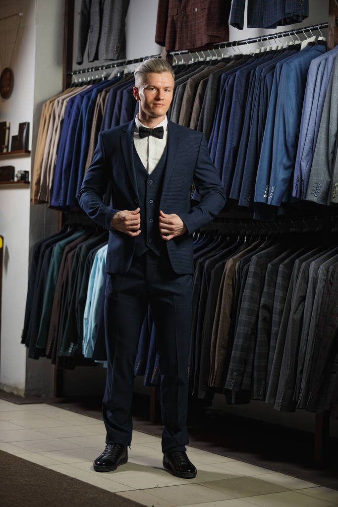 Guapo hombre de negocios caucásico vestido con el traje en la tienda de traje
 - Foto, imagen
