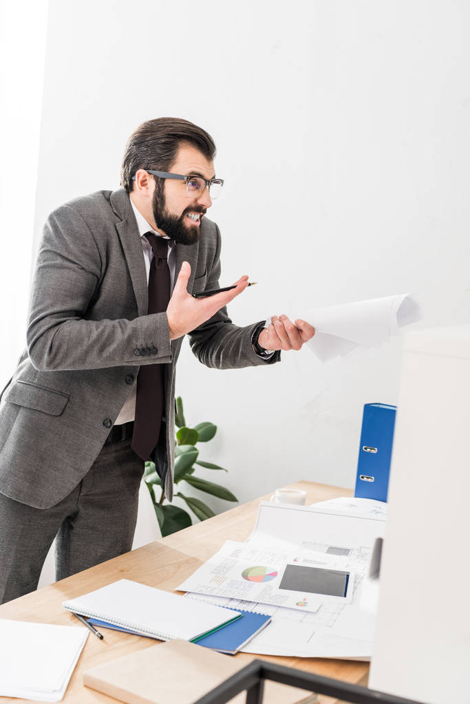 zirytowany biznesmen posiadania dokumentów i krzyczeć na kogoś - Zdjęcie, obraz