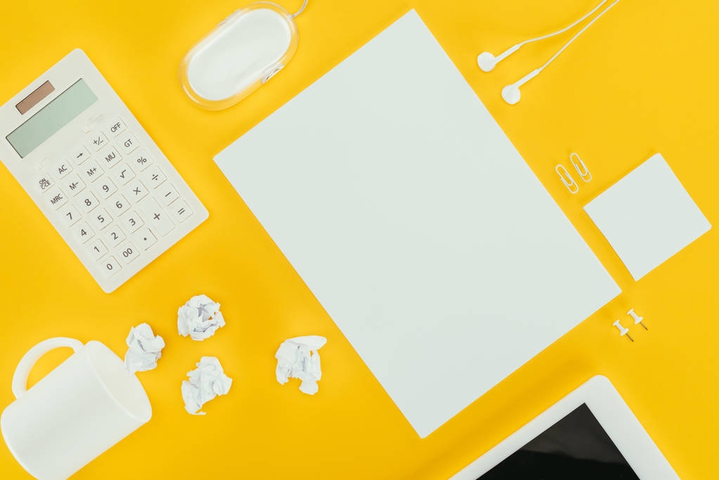 vista superior de la hoja de papel en blanco, papeles arrugados, notas, calculadora y ratón de ordenador aislados en amarillo
 - Foto, Imagen