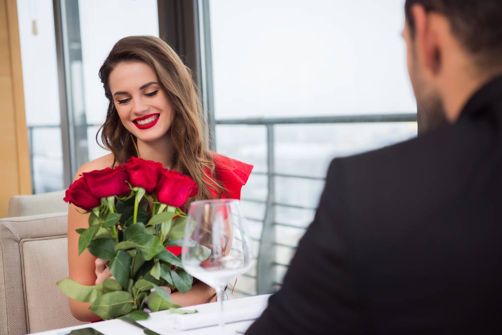 csokor Rózsa alatt romantikus dátum barátja étteremben, mosolygós nő Szent Valentin nap - Fotó, kép