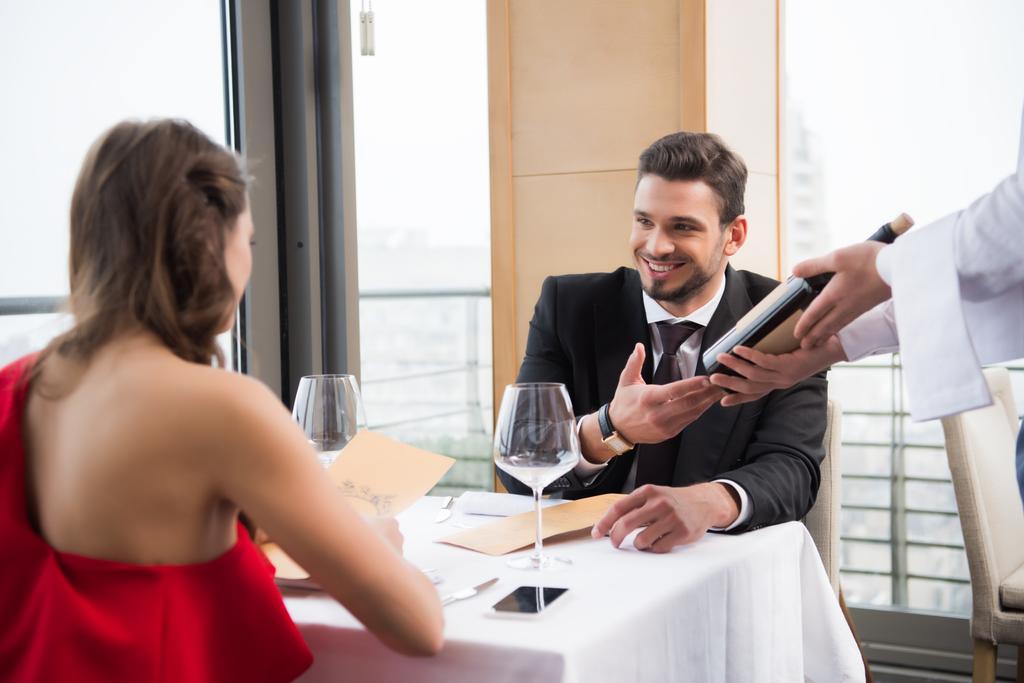 Μερική άποψη του το ζευγάρι που έχει ρομαντική ημερομηνία στο εστιατόριο την ημέρα Αγίου Βαλεντίνου - Φωτογραφία, εικόνα
