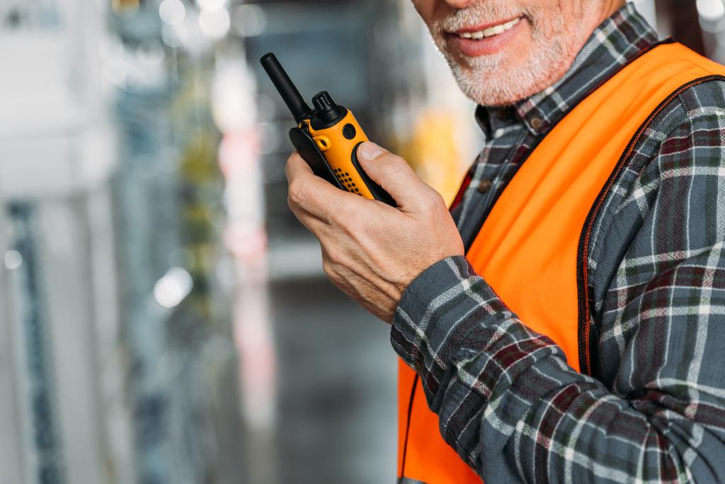 vista ritagliata del lavoratore anziano utilizzando walkie talkie nel magazzino
 - Foto, immagini