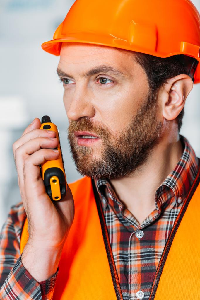 trabajador en casco usando walkie talkie
 - Foto, Imagen