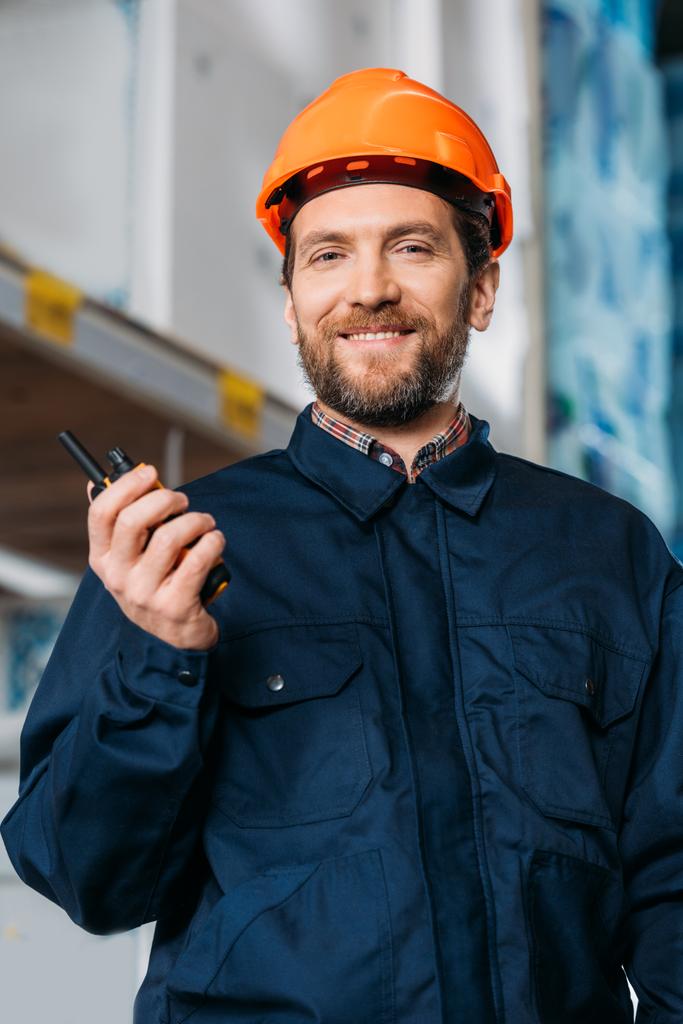 mannelijke werknemer in helm met walkie talkie in de scheepvaart voorraad - Foto, afbeelding
