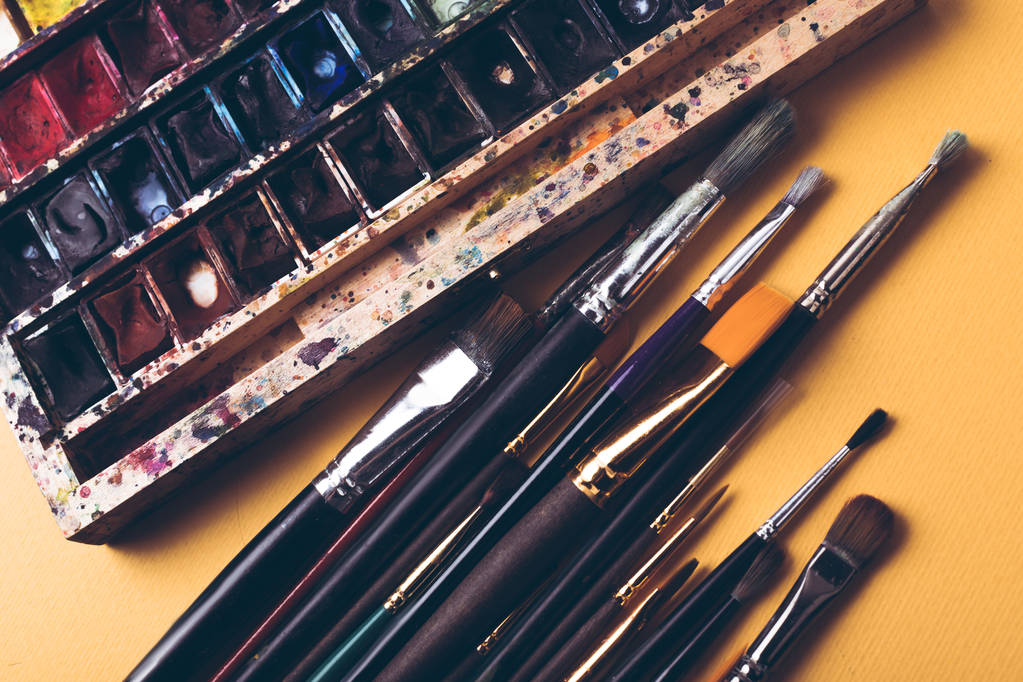 Boya fırçaları ve suluboya Üstten Görünüm Tasarımcısı işyerinde boyalar  - Fotoğraf, Görsel