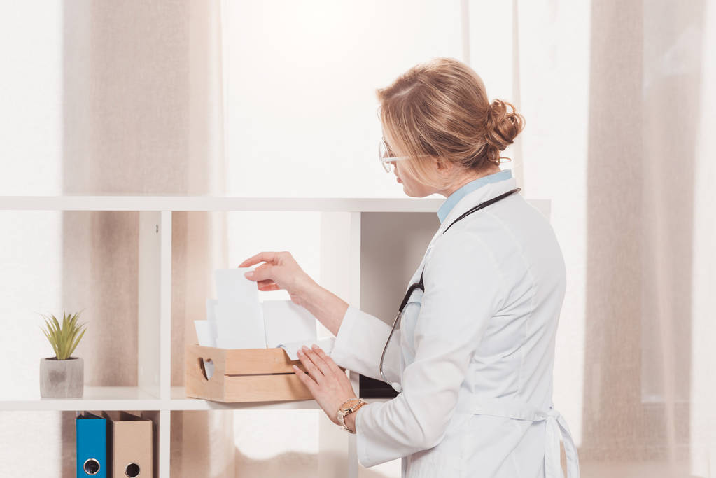 vista laterale del medico in camice bianco che lavora con gli spazi vuoti in clinica
 - Foto, immagini
