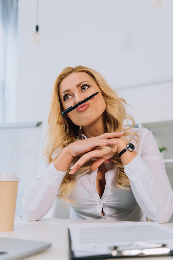 businesswoman grimacing and making mustache with pen - Photo, Image