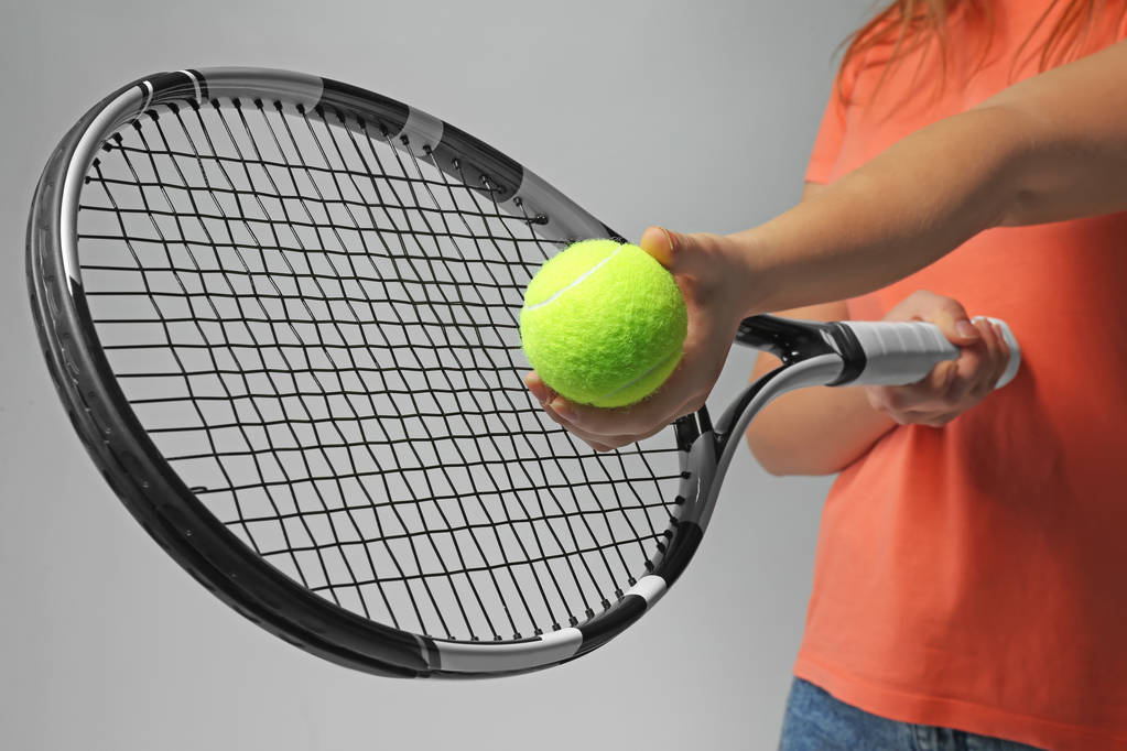 テニス ラケット、ライトグレーの背景の上にボールを持つ女性 - 写真・画像