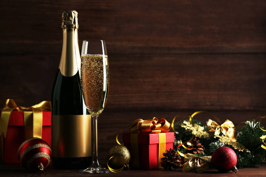 Champagne bottle with glass and christmas decorations on wooden table - Photo, Image