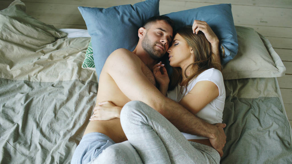 Νεαρό ζευγάρι όμορφη και στοργική, φιλιά στο κρεβάτι το πρωί - Φωτογραφία, εικόνα
