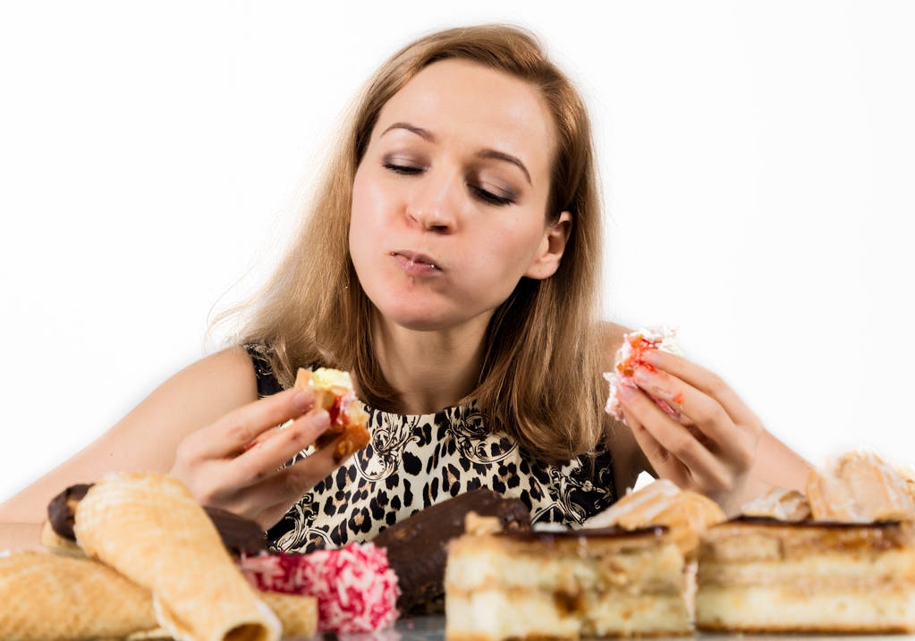 gulzigaard vrouw cupcakes met frenzy na lange dieet eten - Foto, afbeelding