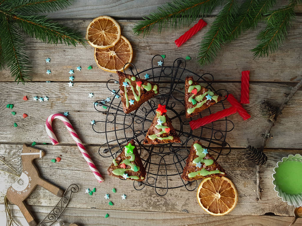 Weihnachtsessen, leckere Schokoladenbrownies in Tannenbaumform auf rustikalem Holzgrund - Foto, Bild