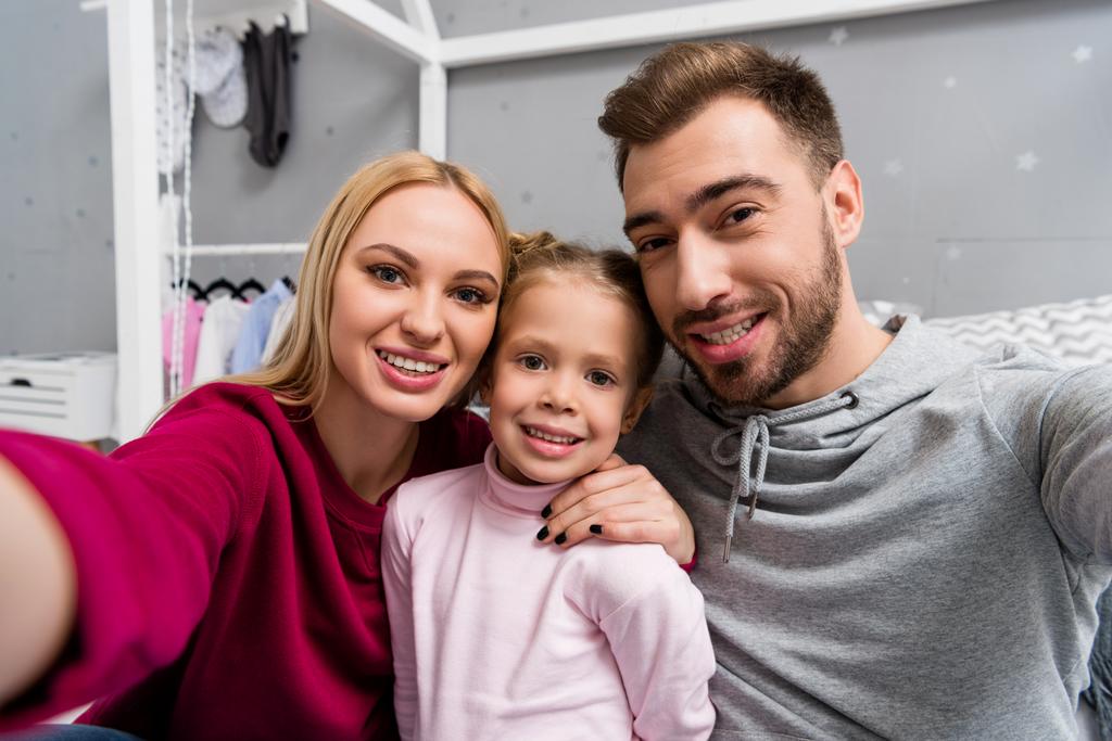 glückliche junge Familie macht Selfie im Kinderzimmer - Foto, Bild