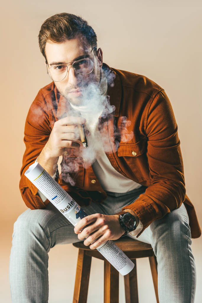 portrait d'homme d'affaires élégant avec cigare et journal d'affaires dans les mains isolé sur beige
 - Photo, image