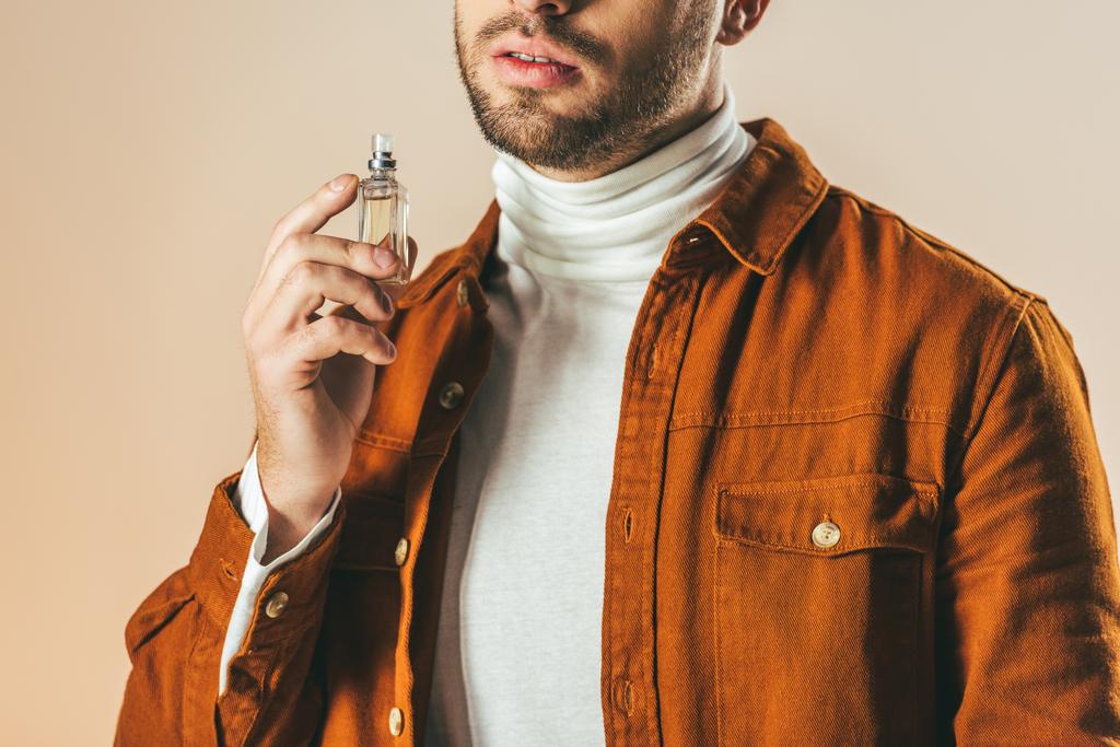 recortado tiro de hombre con estilo aplicando perfume aislado en beige
 - Foto, Imagen