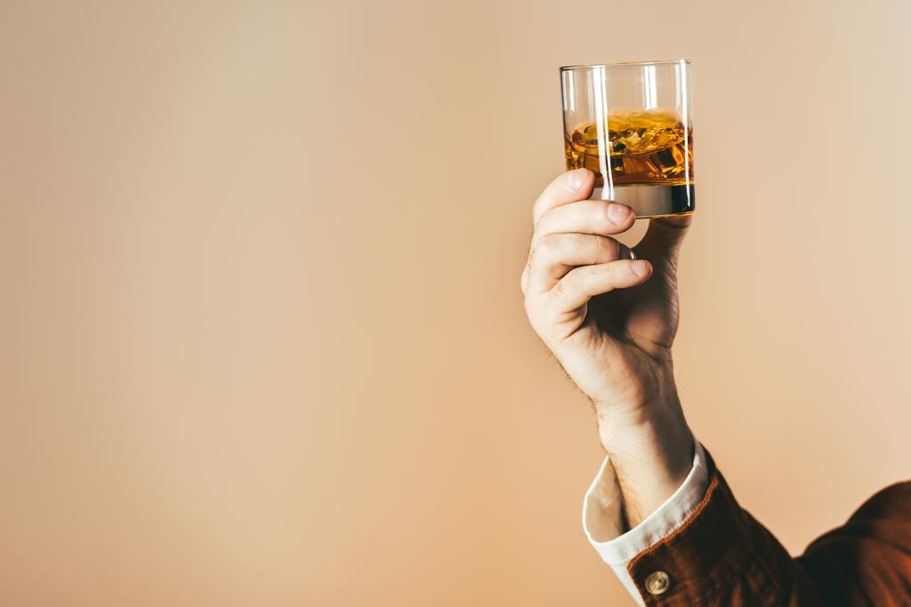 Schnappschuss von Mann mit Glas Whiskey isoliert auf Beige - Foto, Bild
