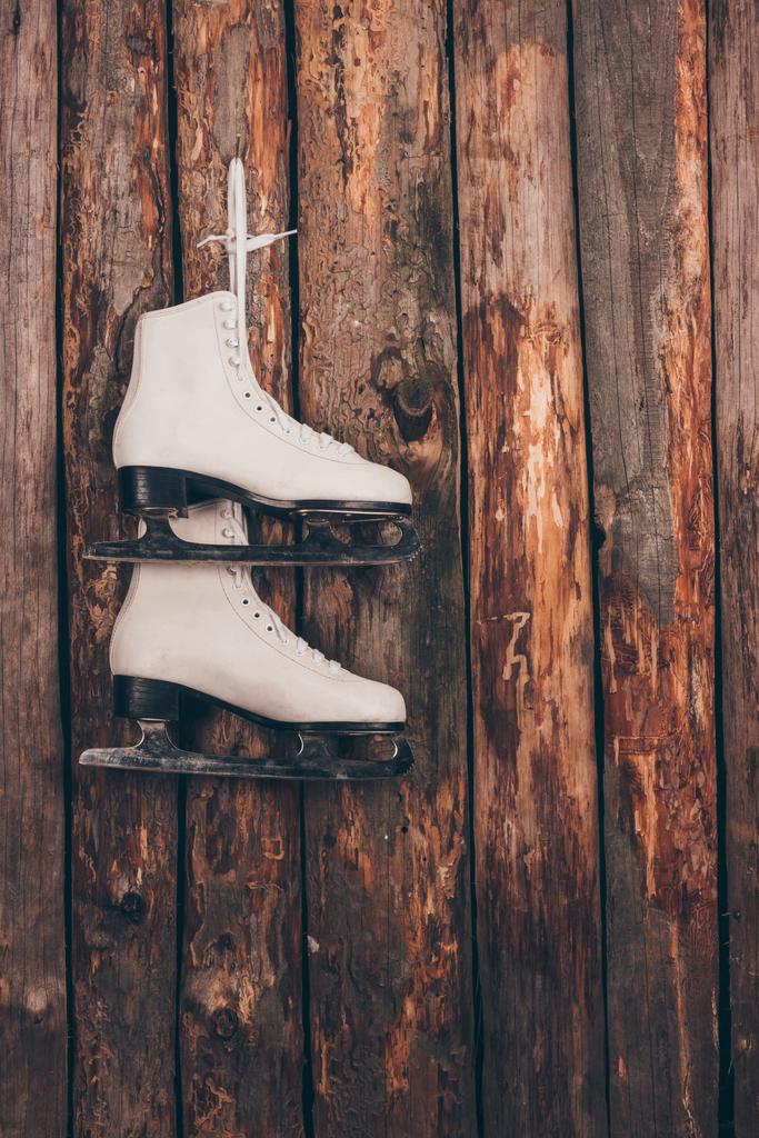 木製の粗末な壁に掛かっている白いスケート靴 - 写真・画像