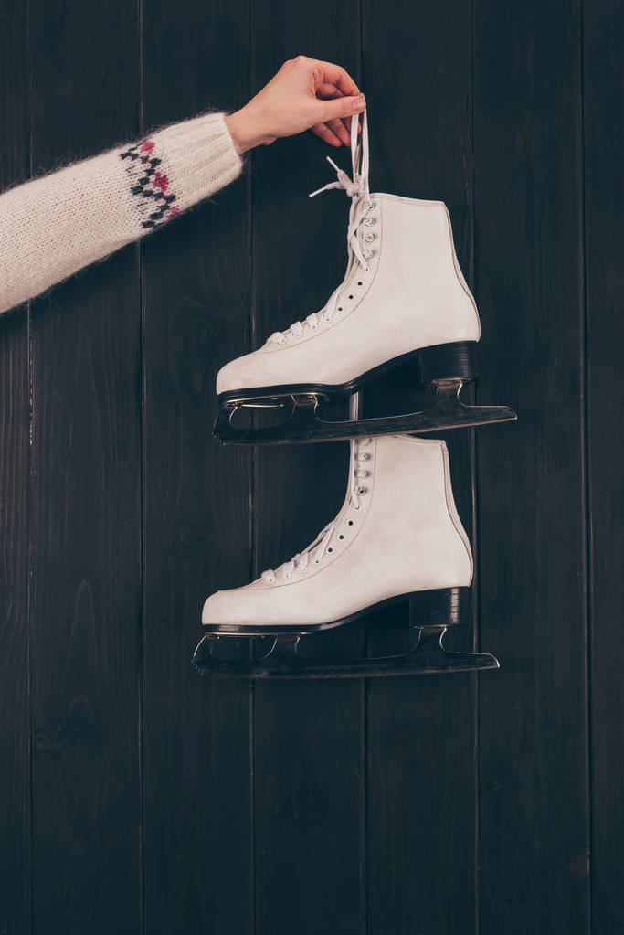 cropped image of woman holding pair of white skates on gray  - Photo, Image