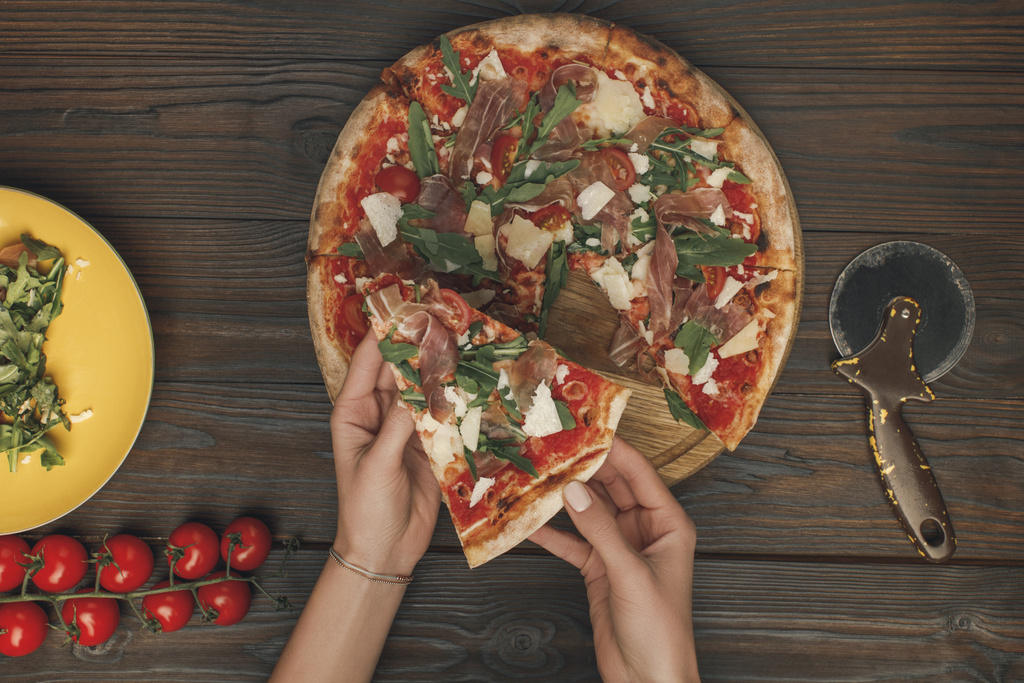 partial view of female hands and homemade italian pizza on wooden surface - Photo, Image