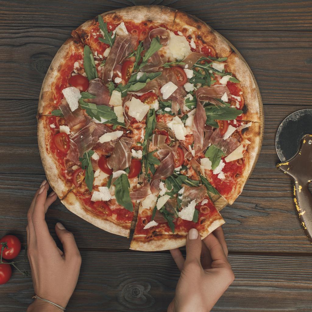 osittainen näkymä nainen tilalla pala italialaista pizzaa
 - Valokuva, kuva