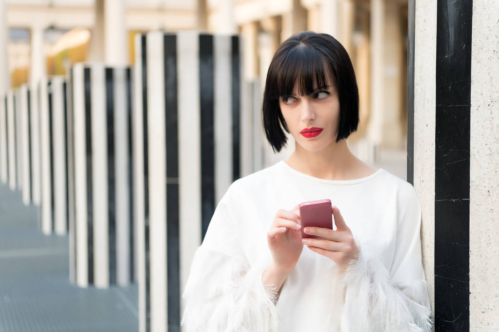 Dziewczyna używa telefonu komórkowego w Paryżu, Francja - Zdjęcie, obraz