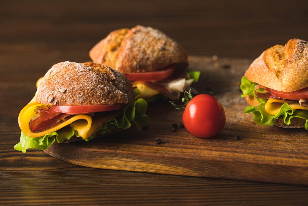 sandwichs au fromage et tomate cerise sur planche à découper
 - Photo, image