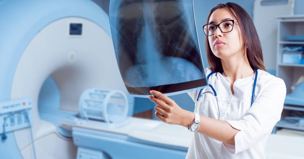 Jovem médica olhando para um filme de raios-x no quarto do hospital
. - Foto, Imagem