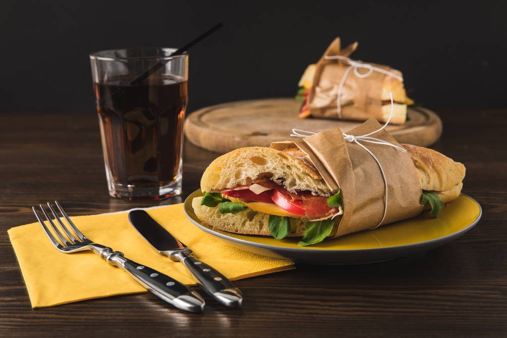 cooked panini on yellow plate and knife with fork - Photo, Image
