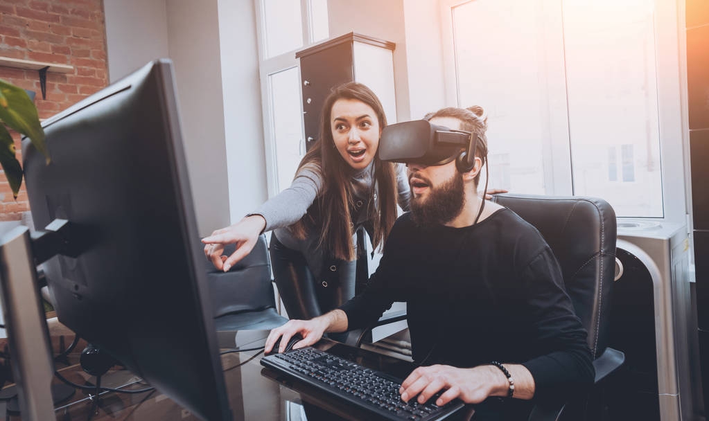Hombre joven con mujeres trabajadoras de oficina creativas probando gafas VR y divirtiéndose
 - Foto, imagen
