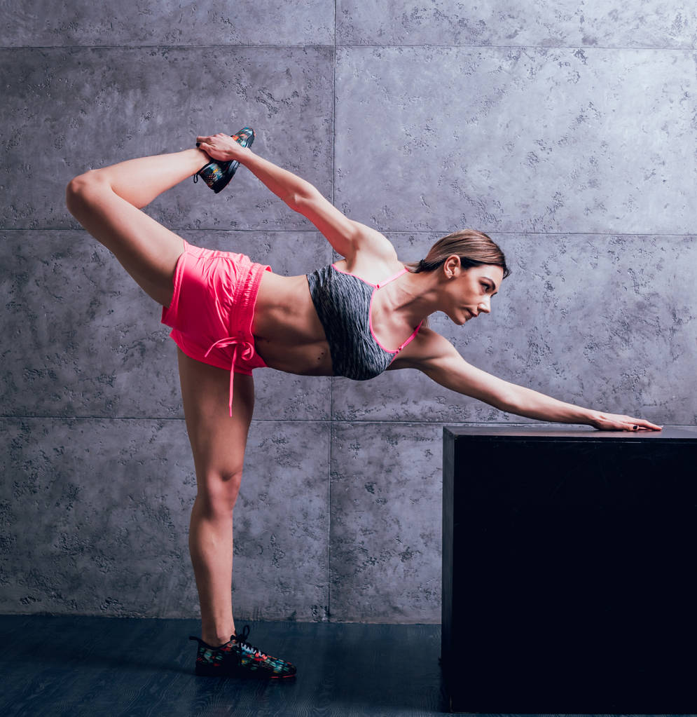 Joven atlética mujer caucásica posando en el estudio y haciendo diferentes ejercicios
. - Foto, imagen