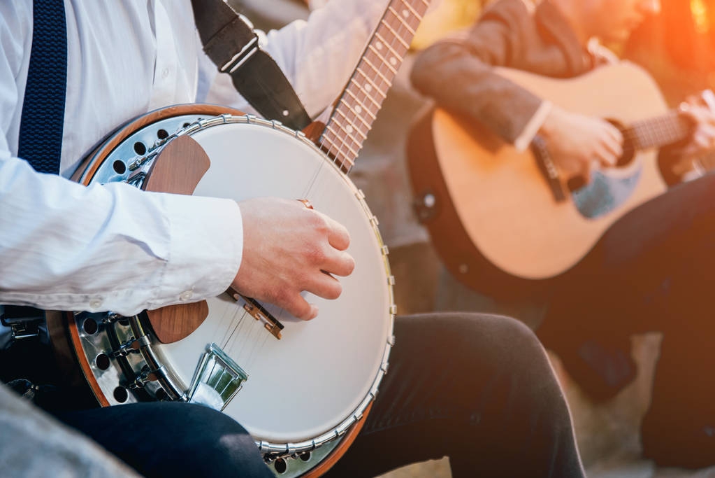 Rajattu kuva muusikko pelaa banjo kadulla
 - Valokuva, kuva