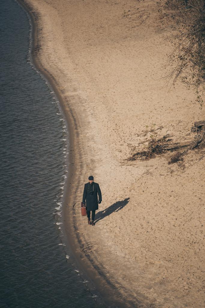 μεγάλη γωνία άποψη για τον άνθρωπο με τις αποσκευές, με τα πόδια από την αμμώδη παραλία το φθινόπωρο - Φωτογραφία, εικόνα