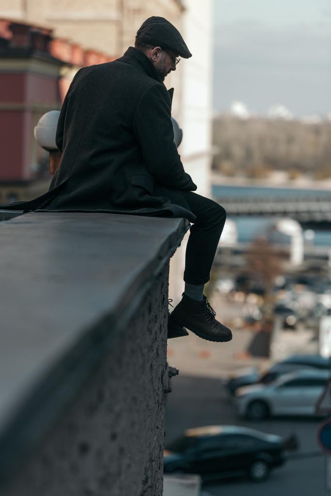 bell'uomo di mezza età seduto sul tetto dell'edificio
 - Foto, immagini