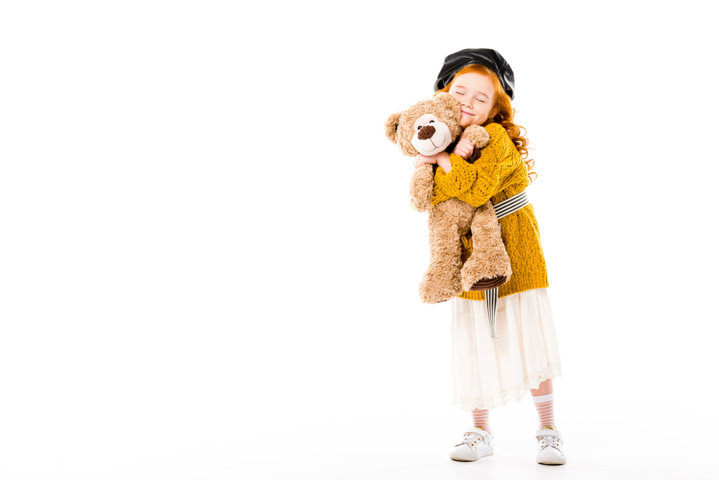 usmívající se dítě zrzavé vlasy objímání medvídek se zavřenýma očima izolované na bílém    - Fotografie, Obrázek