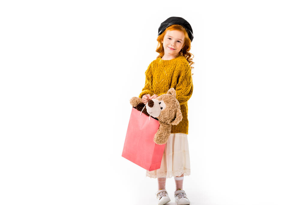 rotes Haar Kind hält Teddybär in Einkaufstasche isoliert auf weiß - Foto, Bild