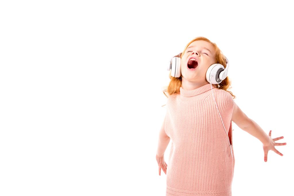 rotes Haar Kind mit Kopfhörern schreit und tanzt isoliert auf weiß - Foto, Bild