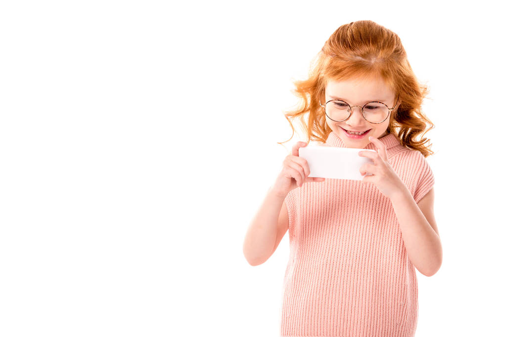 παιδί με μαλλιά τζίντζερ λήψη φωτογραφιών με smartphone που απομονώνονται σε λευκό - Φωτογραφία, εικόνα