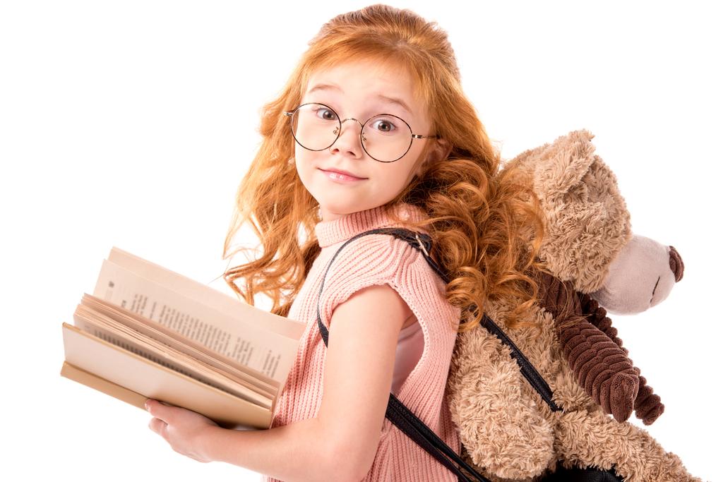 червоне волосся дитина стоїть з книгою і плюшевим ведмедем ізольовано на білому
 - Фото, зображення