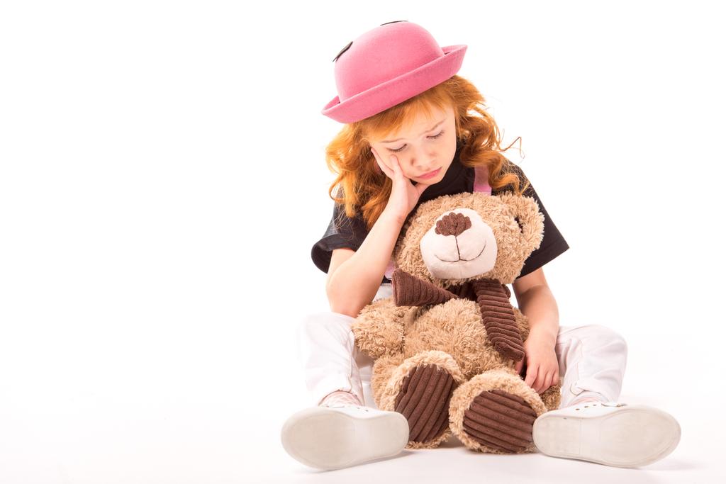 白のクマのぬいぐるみと座っている悲しい赤髪の子供 - 写真・画像