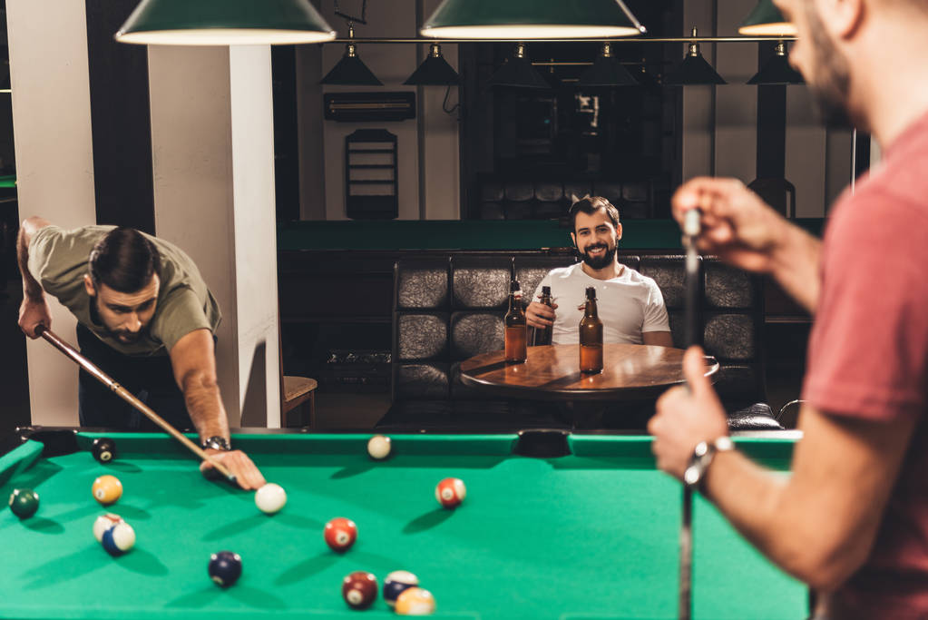group of young successful handsome men playing in pool at bar - Photo, Image