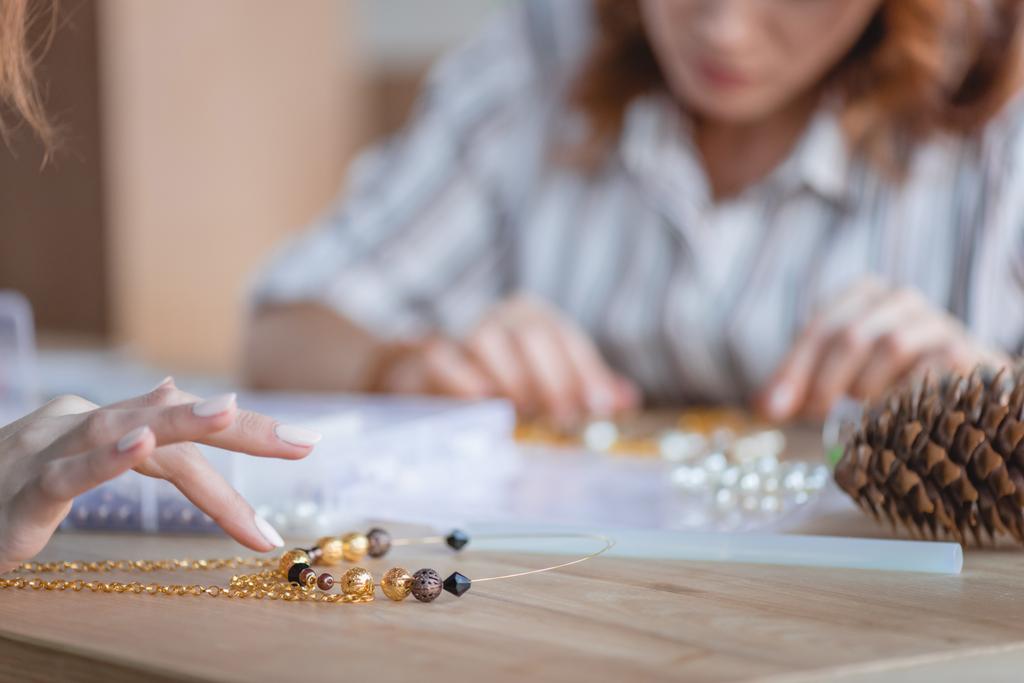 plan recadré de femmes faisant des accessoires de perles en atelier
 - Photo, image