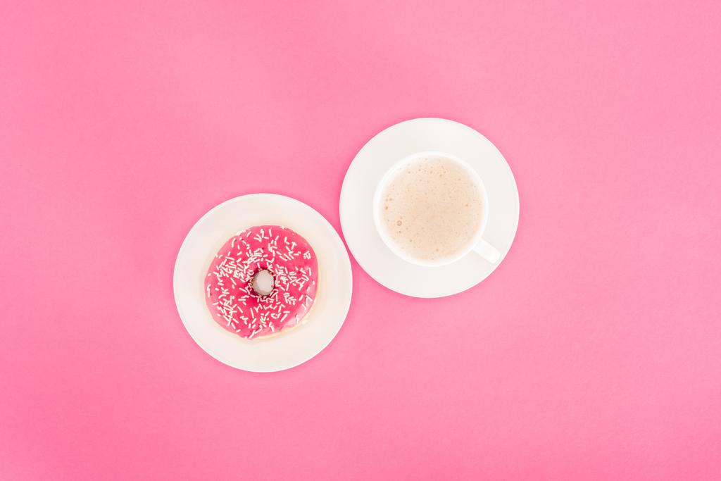 vista superior de donut con taza de café aislado en rosa
 - Foto, imagen