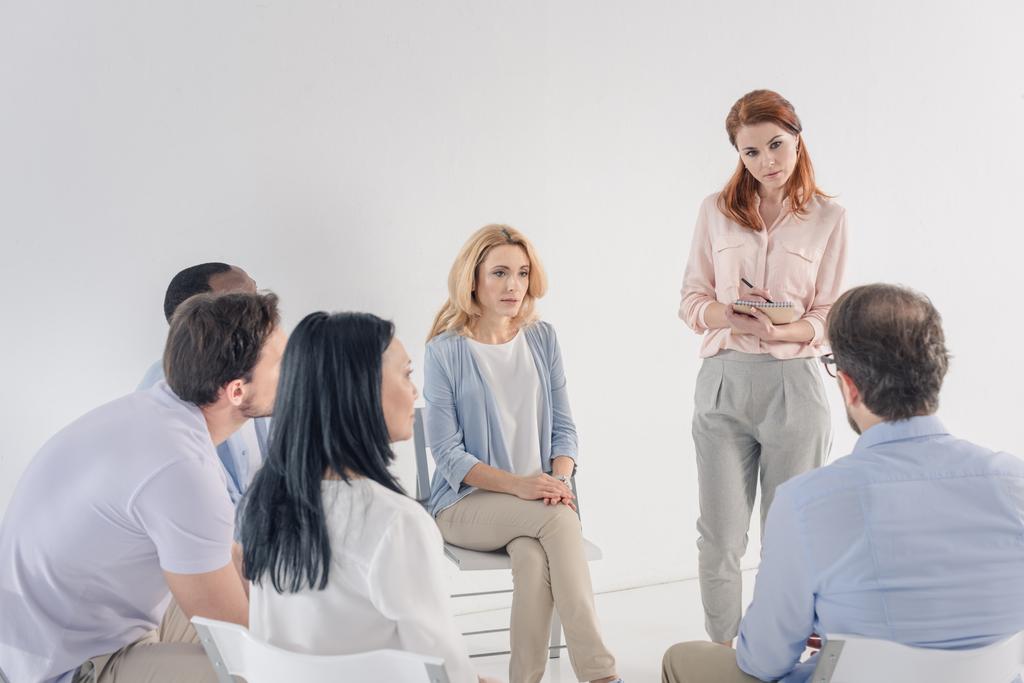 psicoterapeuta tomar notas e trabalhar com pessoas multiétnicas maduras durante a terapia de grupo
 - Foto, Imagem
