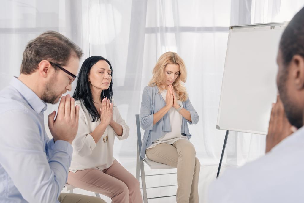 обрізаний знімок анонімної групи багатоетнічних людей, які моляться під час терапії
  - Фото, зображення