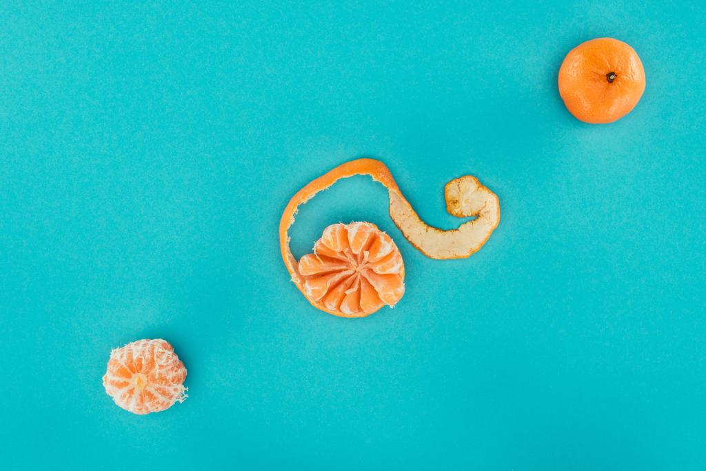 vlakke leggen met gearrangeerde rijpe mandarijnen geïsoleerd op blauw - Foto, afbeelding