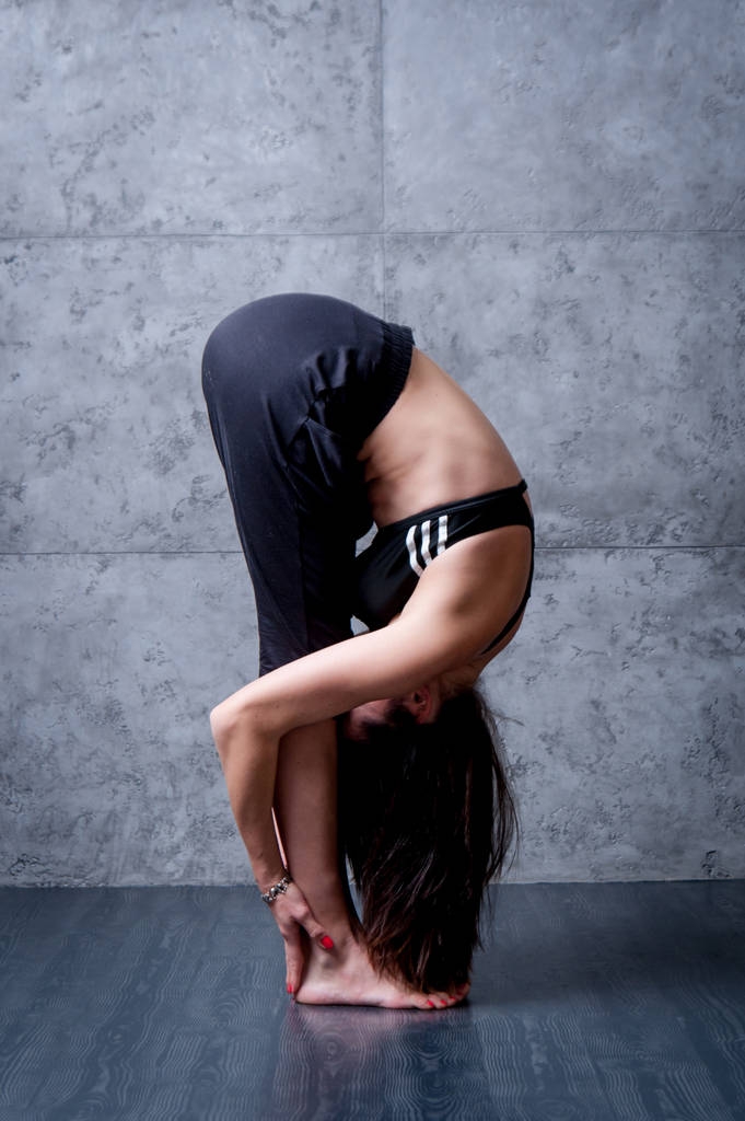 Frau praktiziert Yoga an grauer Wand. - Foto, Bild