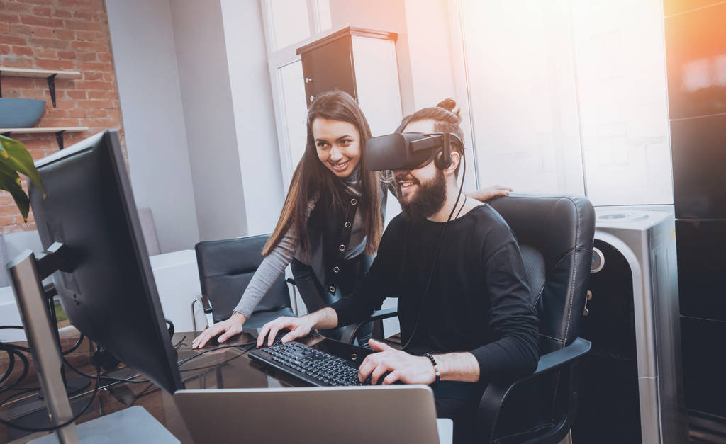 Hombre joven con mujeres trabajadoras de oficina creativas probando gafas VR y divirtiéndose
 - Foto, Imagen