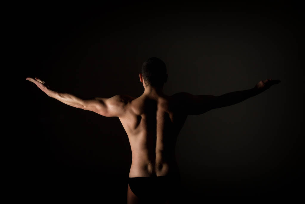 starker muskulöser Mann Torso posiert auf schwarzem Hintergrund - Foto, Bild
