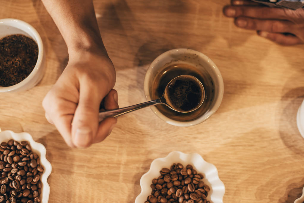 aromalı kahve test ederken kaşık tutan adamın kırpılmış atış - Fotoğraf, Görsel